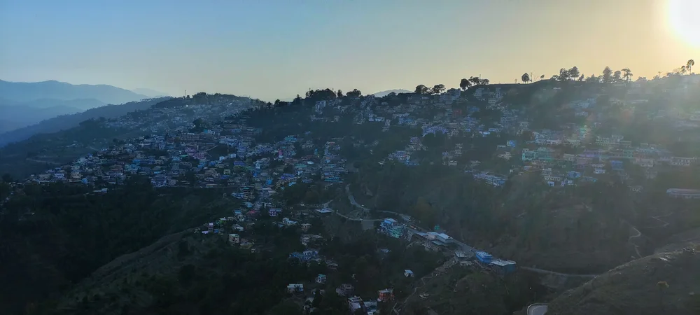 Almora hillside homes and distant mountain ridges at sunset